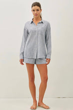 Load image into Gallery viewer, Woman wearing a light blue checkered shirt and shorts on a white background