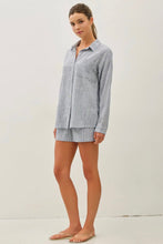 Load image into Gallery viewer, Woman wearing a light blue checkered shirt and shorts on a white background