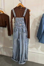 Load image into Gallery viewer, Folded jeans and shirts on a white surface