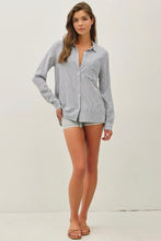 Load image into Gallery viewer, Woman wearing a light gray button-up shirt and shorts on a white background
