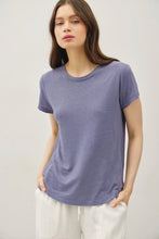 Load image into Gallery viewer, Woman wearing a purple t-shirt against a plain background