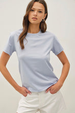 Load image into Gallery viewer, Woman wearing a light blue t-shirt and white shorts on a plain background