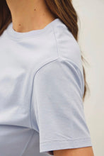 Load image into Gallery viewer, Close-up of a person wearing a light gray t-shirt on a plain background