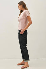 Load image into Gallery viewer, Woman wearing a light pink t-shirt and black jeans against a white background