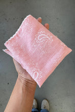 Load image into Gallery viewer, Pink handkerchief with lace patterns held by a person on a concrete floor.