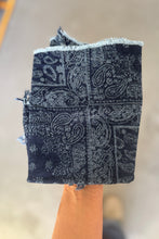 Load image into Gallery viewer, Black and white patterned bandana held by a hand against a blurred background