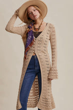 Load image into Gallery viewer, Woman wearing a long beige cardigan, blue jeans, and a wide-brimmed hat on a plain background