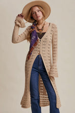 Load image into Gallery viewer, Woman wearing a long beige cardigan, blue jeans, and a wide-brimmed hat on a plain background