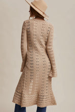 Load image into Gallery viewer, Woman wearing a long, patterned beige dress with a neutral background