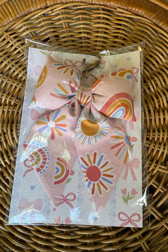 Packaged hair accessories with colorful designs on a wicker surface