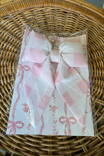 Packaged product with pink bows on a wicker surface