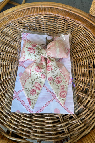 Floral-patterned butterfly toy on a card with a wicker surface