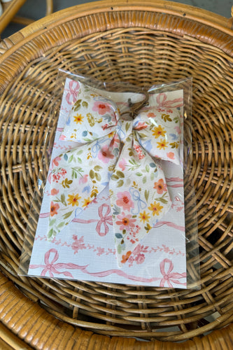 Floral-patterned product in clear packaging on a wicker surface