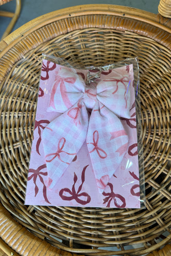 Packaged product with pink bow design on a wicker surface