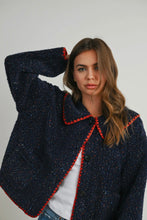 Load image into Gallery viewer, Woman wearing a dark blue textured coat with red trim on a plain background