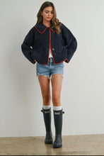 Load image into Gallery viewer, Woman wearing a navy blue jacket with red trim, denim shorts, and black rain boots on a plain background
