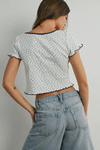 Load image into Gallery viewer, Woman wearing a patterned top and jeans against a plain background