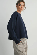 Load image into Gallery viewer, Woman wearing a navy sweater and plaid pants on a plain background