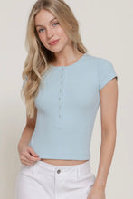 Load image into Gallery viewer, Woman wearing a light blue cropped top with buttons on a plain background