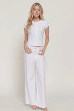 Load image into Gallery viewer, Woman wearing a white top and white pants against a plain background