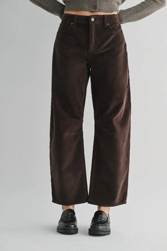 Brown wide-leg pants worn by a person on a gray background