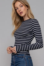 Load image into Gallery viewer, Woman wearing a black and white striped long-sleeve top against a gray background