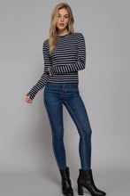 Load image into Gallery viewer, Woman wearing a black and white striped sweater and blue jeans against a gray background