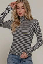 Load image into Gallery viewer, Woman wearing a black and white striped turtleneck sweater against a plain background
