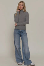 Load image into Gallery viewer, Woman wearing a striped turtleneck and wide-leg jeans against a plain background