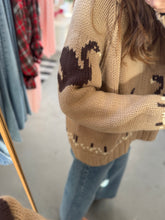 Load image into Gallery viewer, Person wearing a beige sweater with animal patterns in a store setting